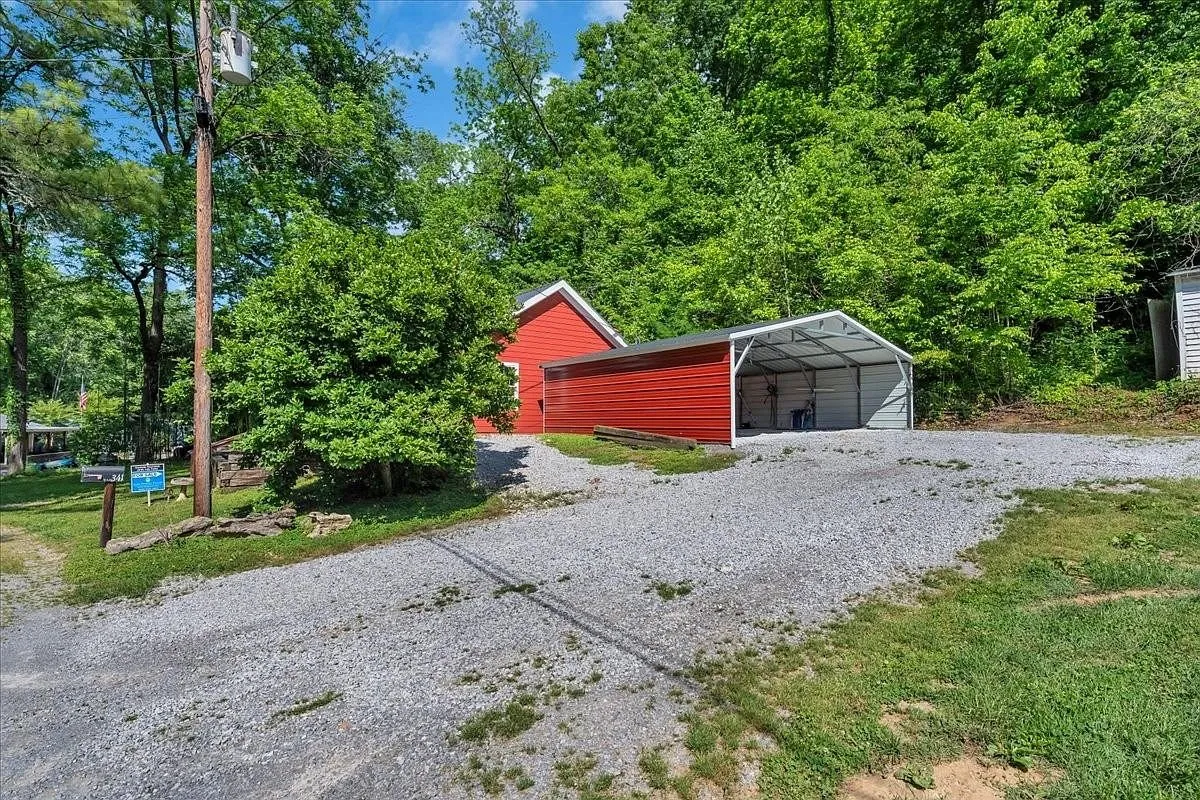 The red cabin seen from the covered porch side, with a flag mounted near the entry