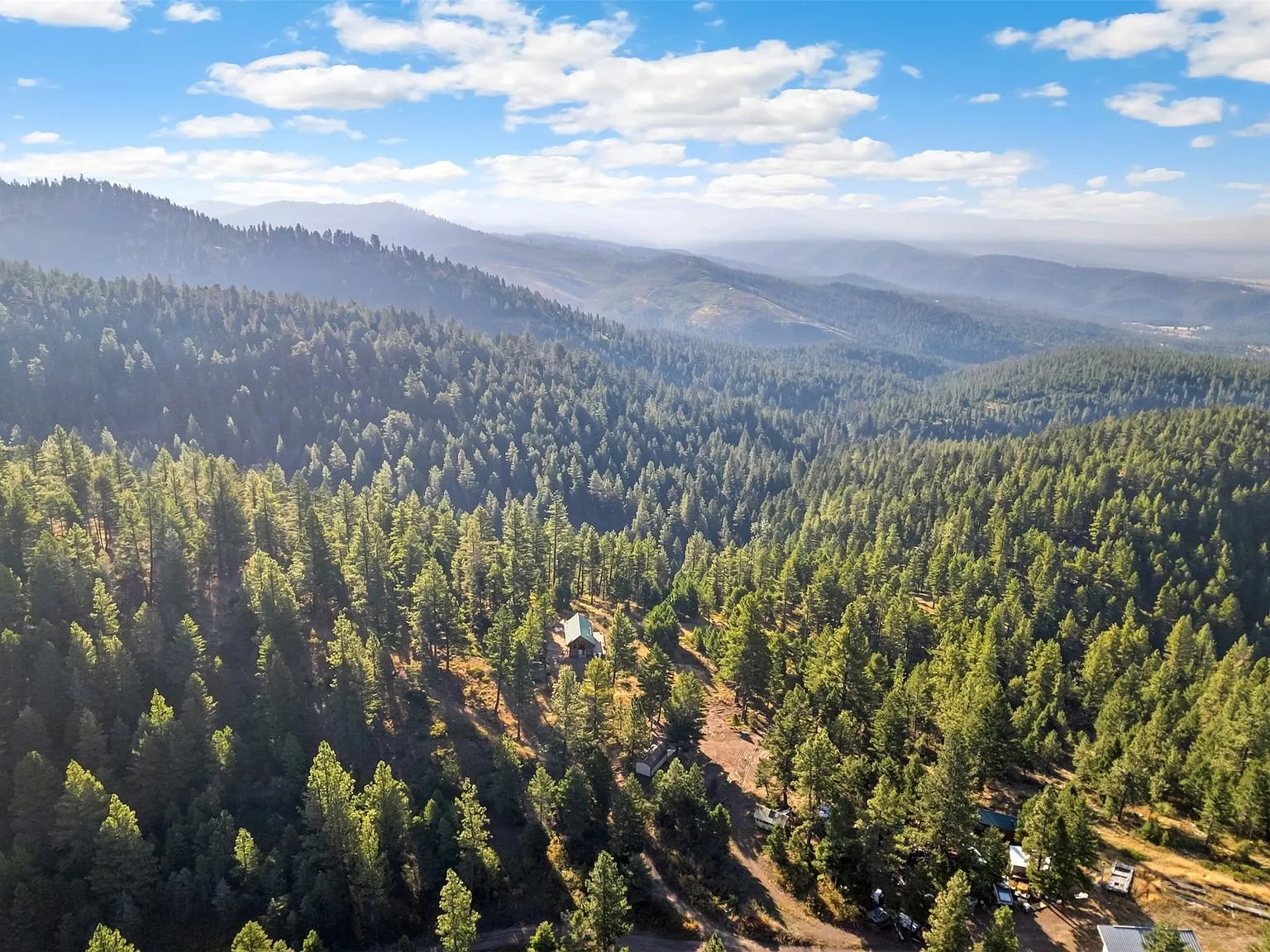 A panoramic aerial view of layered mountain ridges toward the Bitterroot range