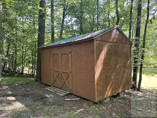 The storage shed at the edge of the trees