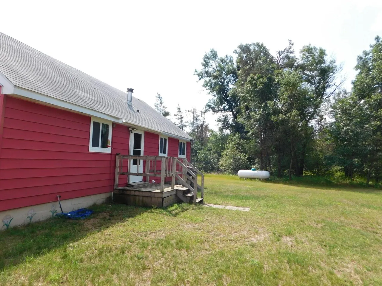 The rear of the cabin from the lawn, deck rail along the back wall