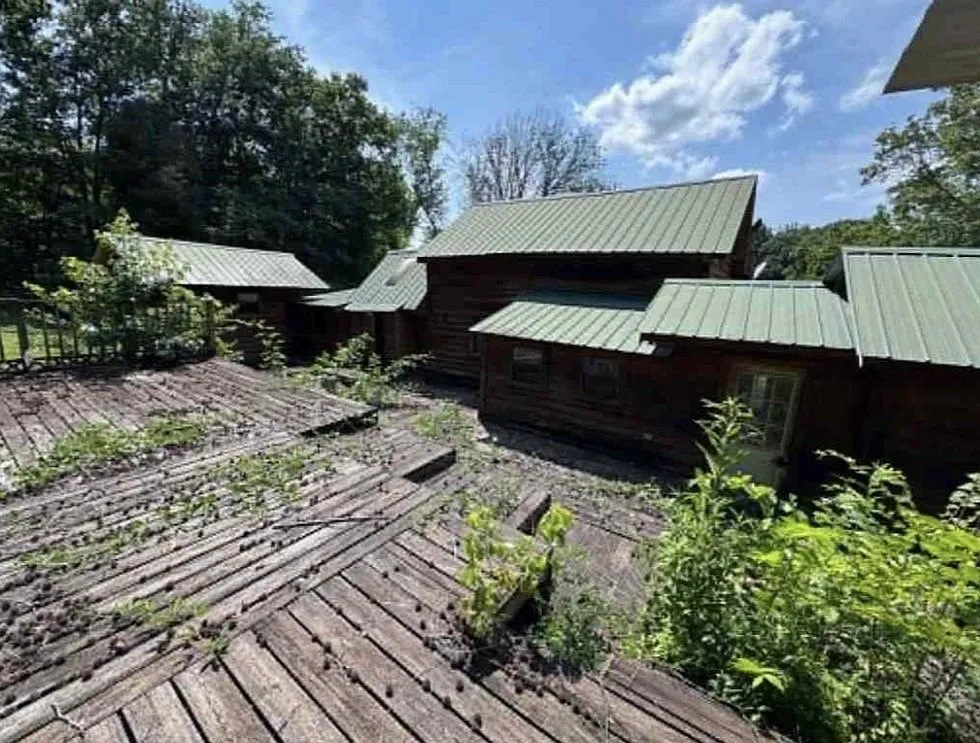 A weathered deck attached to the cabin, boards worn and gapped