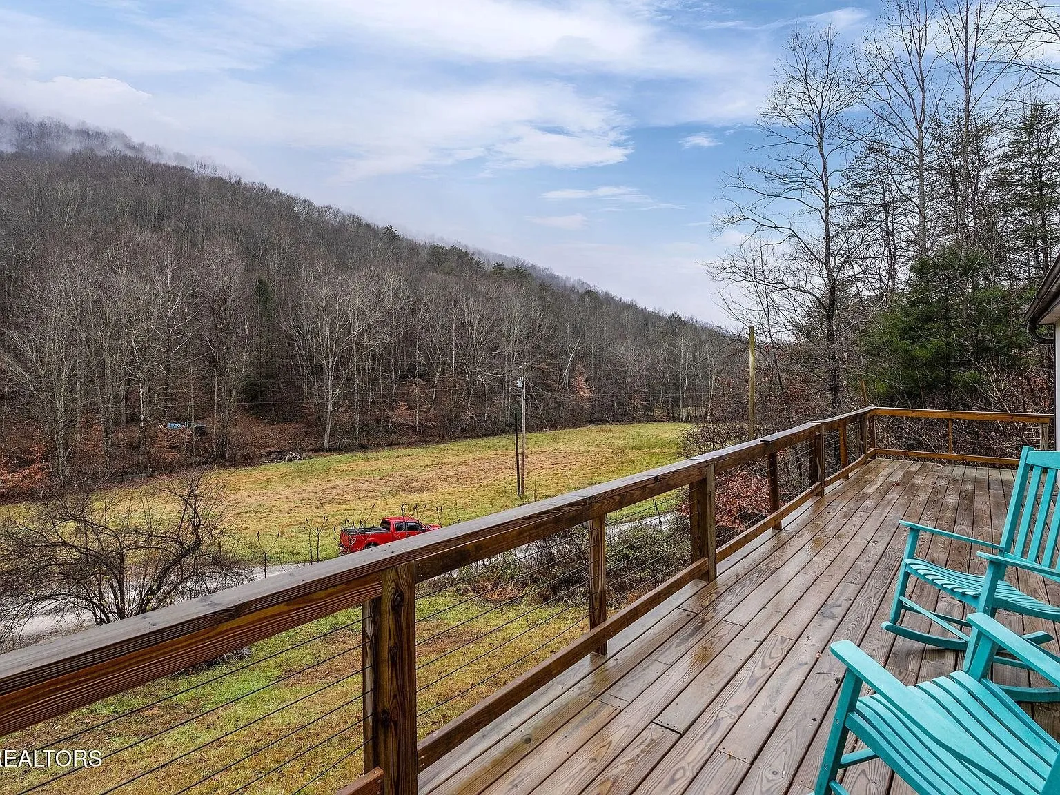 The front deck railing looking out over the sloped yard and woods