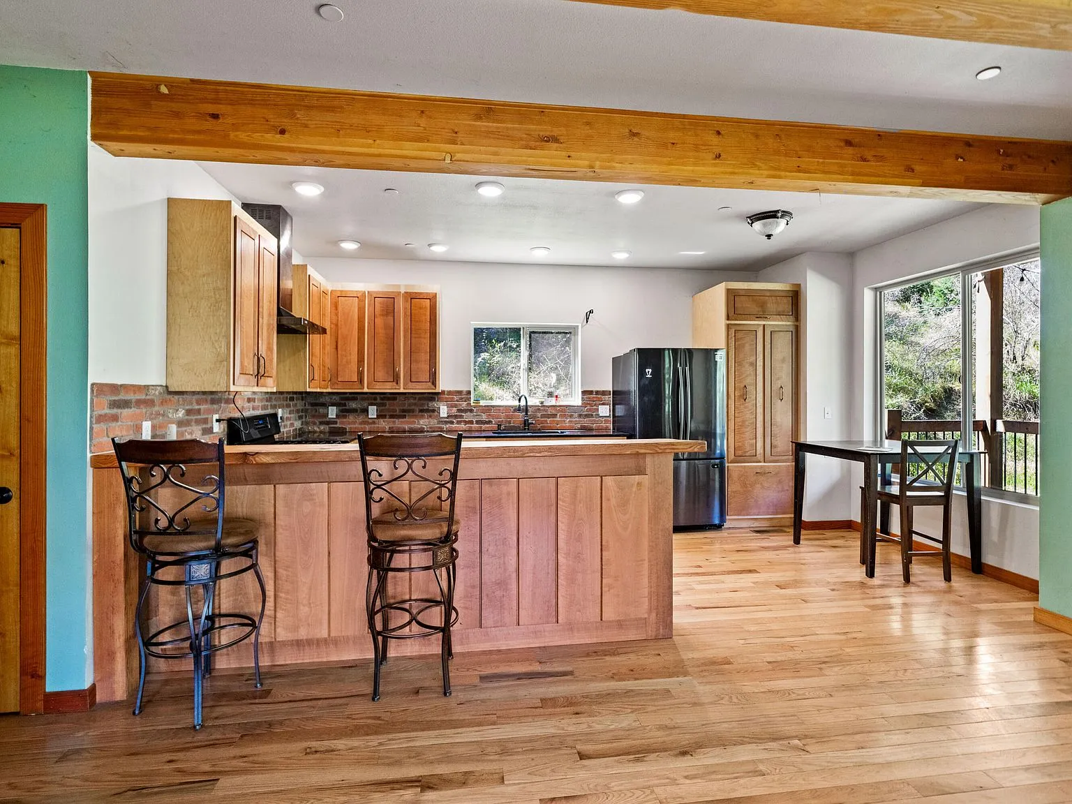The open kitchen and dining area with wood beam ceilings and a breakfast bar