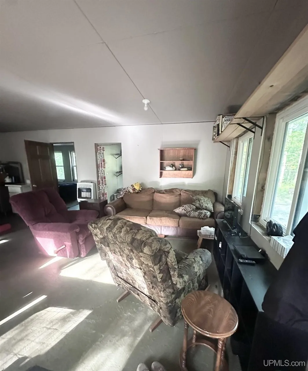 The living room with the sofas, the recliner and the propane wall heater