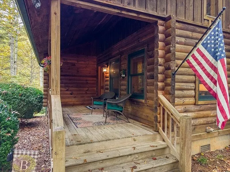 The front porch steps and railing with an American flag hanging