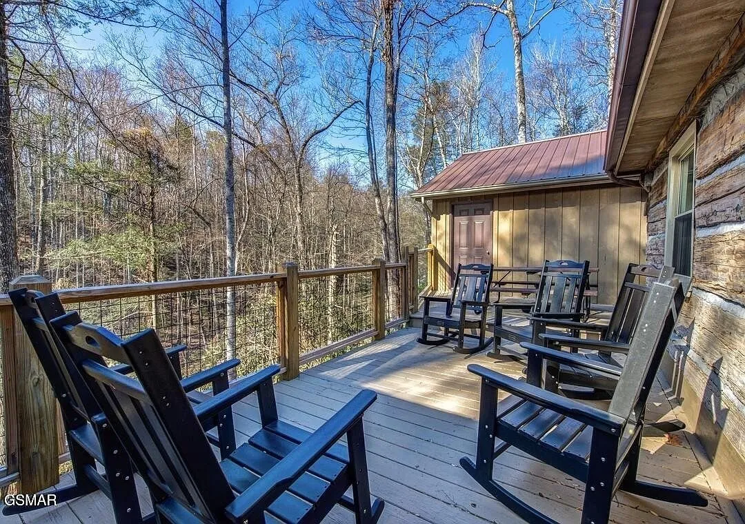 The back deck with rocking chairs and chairs looking into the woods