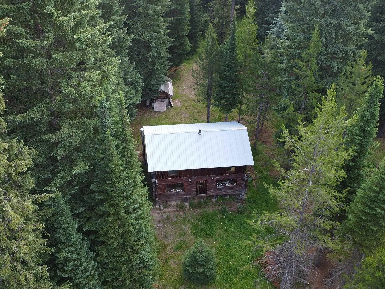 A wide aerial view of the river corridor and the forested valley beyond