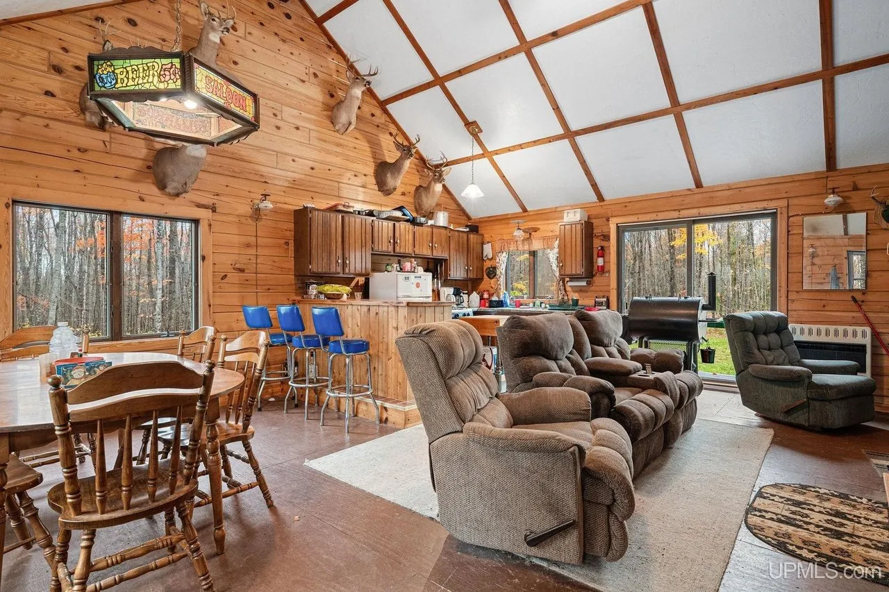 The main room looking through to the kitchen, recliners and a dining table under the vaulted ceiling