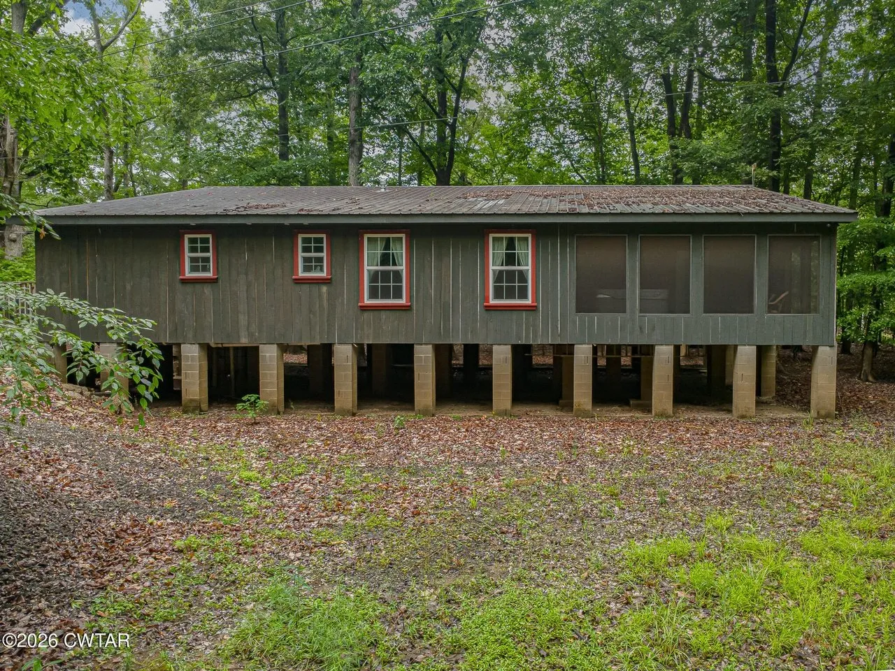 The long side of the cabin from the clearing, screened porch running its length