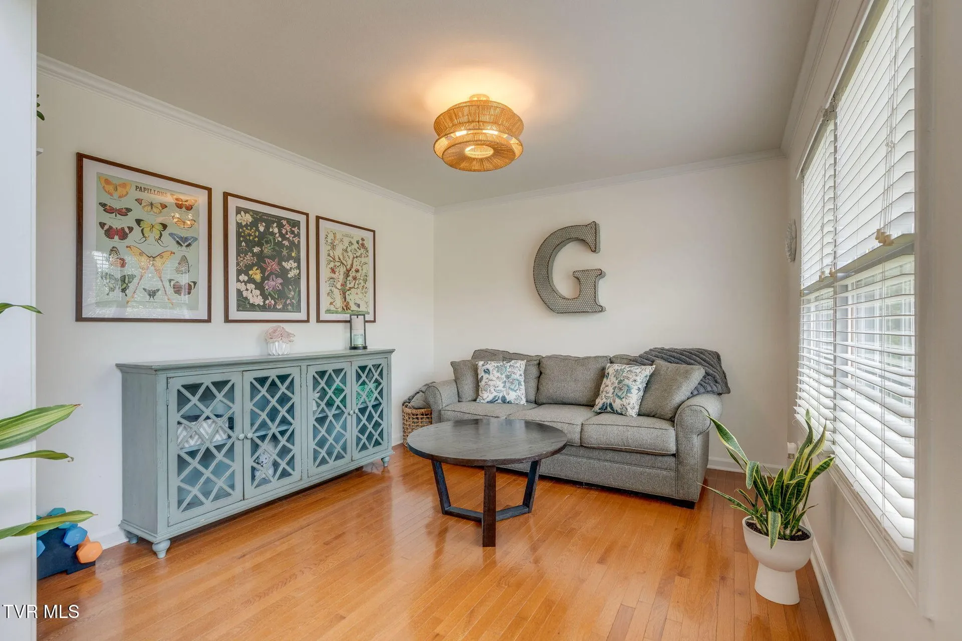 The flex room off the foyer with a sofa, a sideboard and tall windows