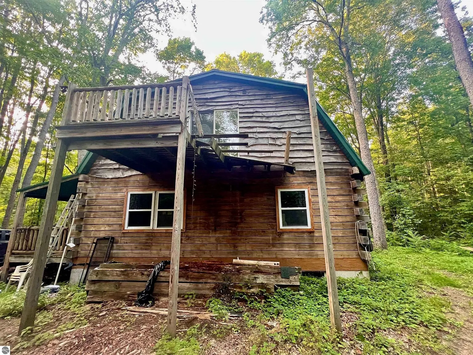 The cabin from the uphill side with the balcony on its posts