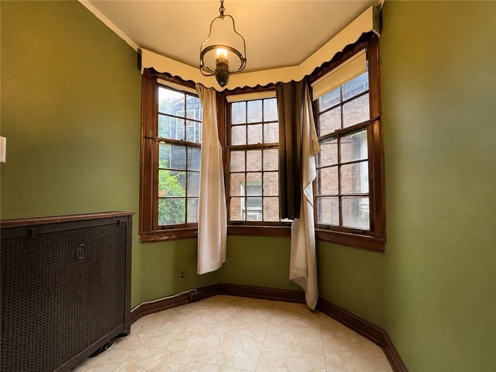 The green sunroom with its bay of windows and a radiator