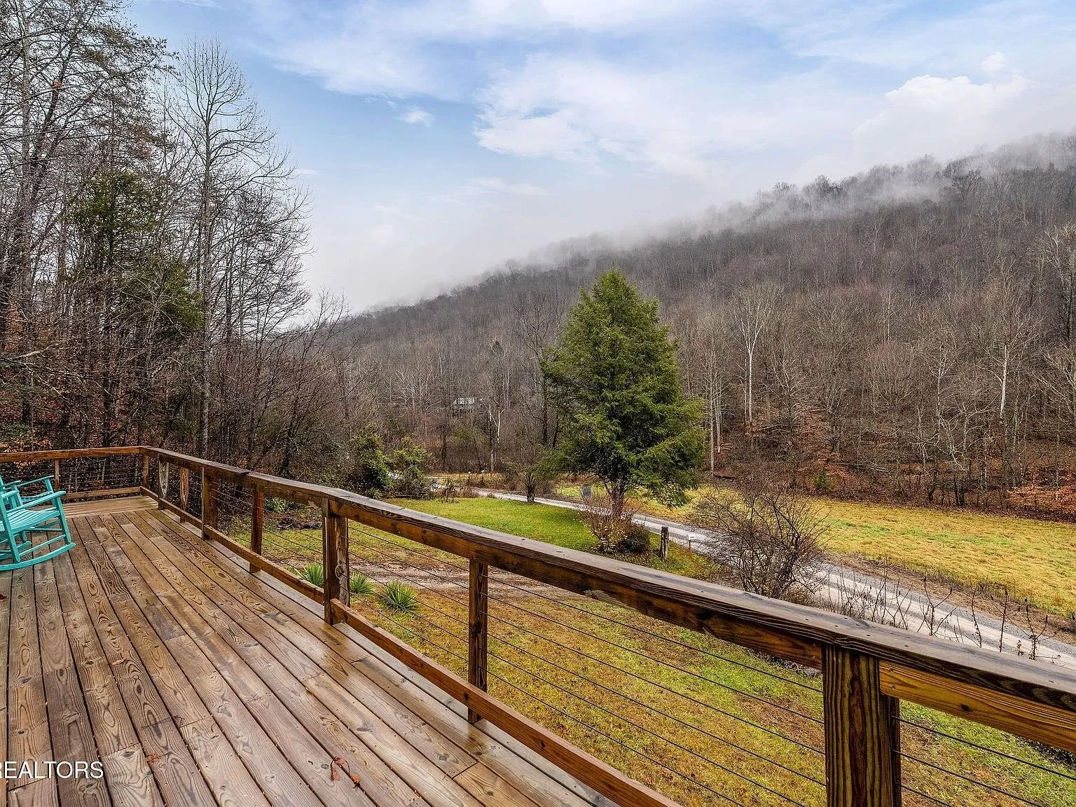 A view from the deck across an open field toward the mountains