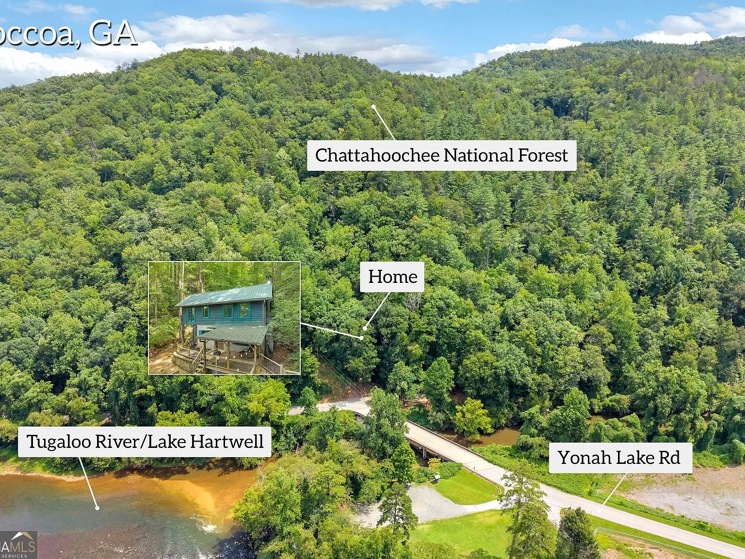 A wide aerial overview of the wooded property relative to the national forest
