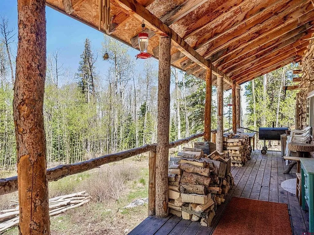 The covered deck with the firewood stacked along the rail