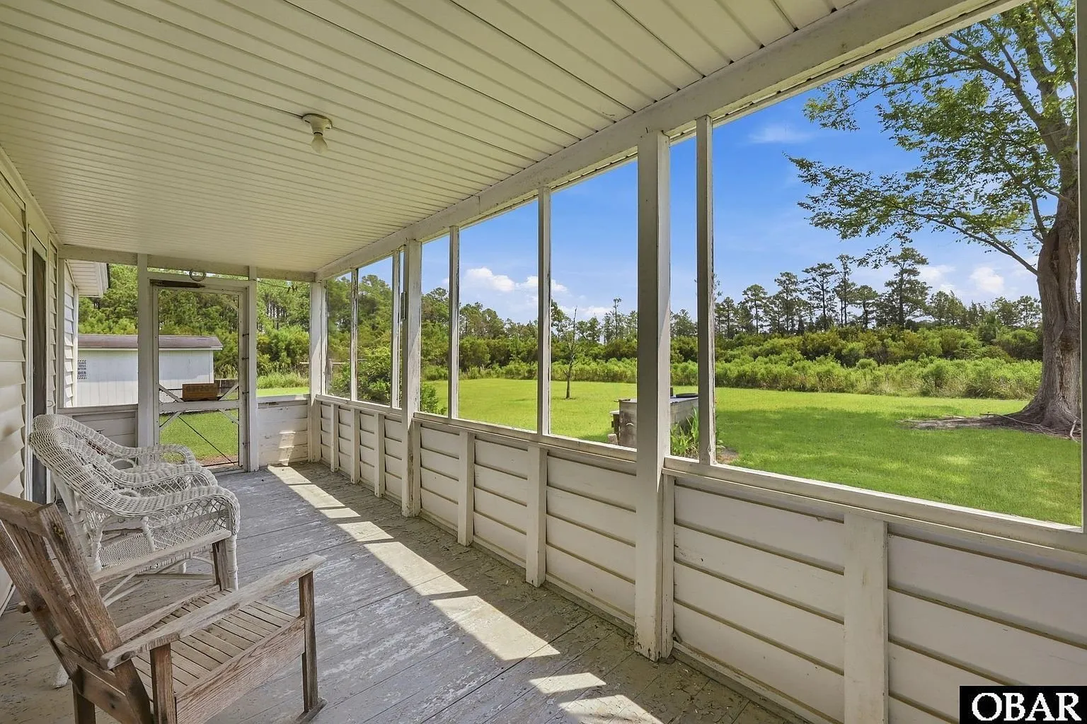 The front porch with wicker chairs looking out to the road