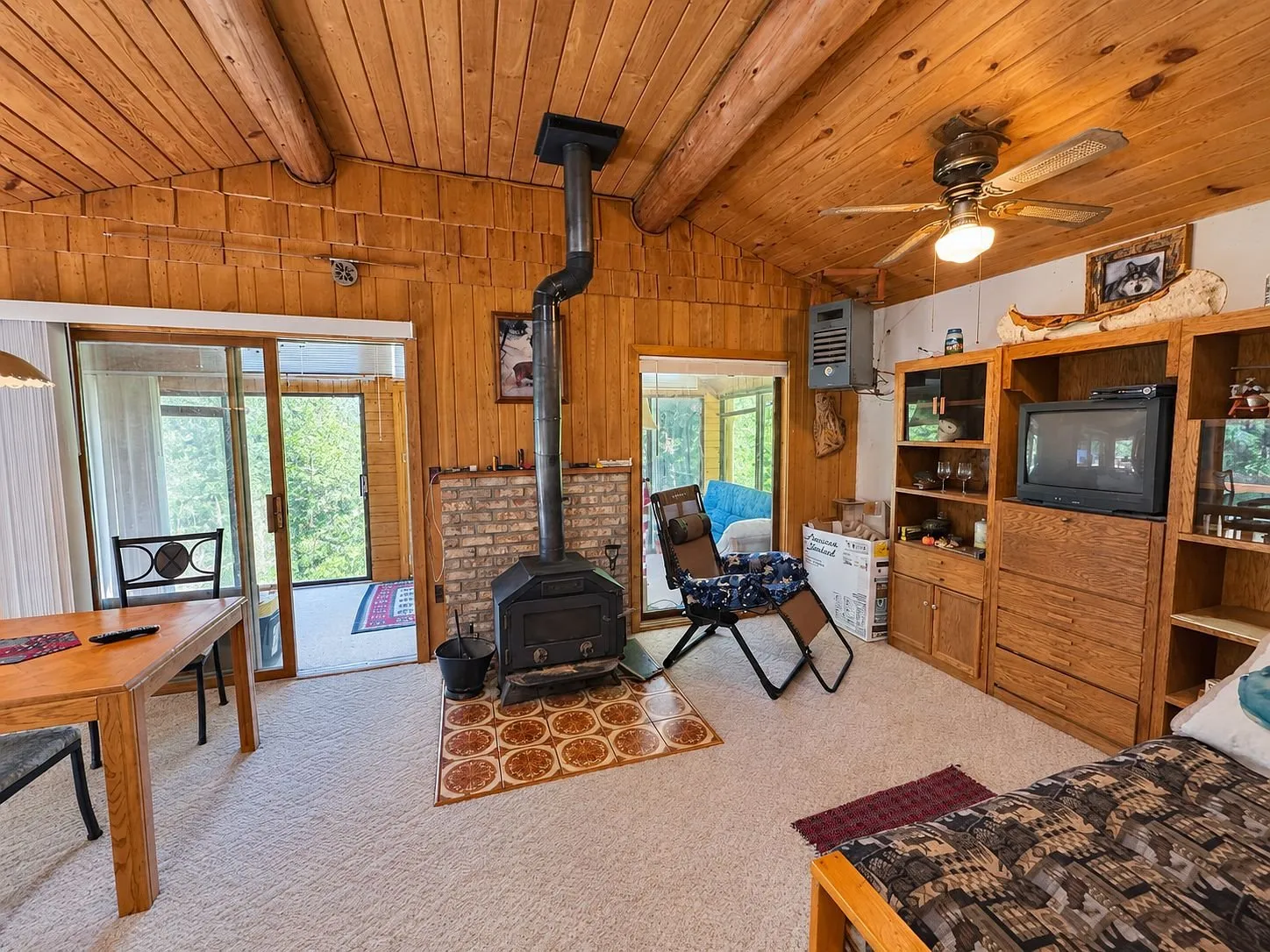 The living room toward the porch with the stove, the table and the television cabinet