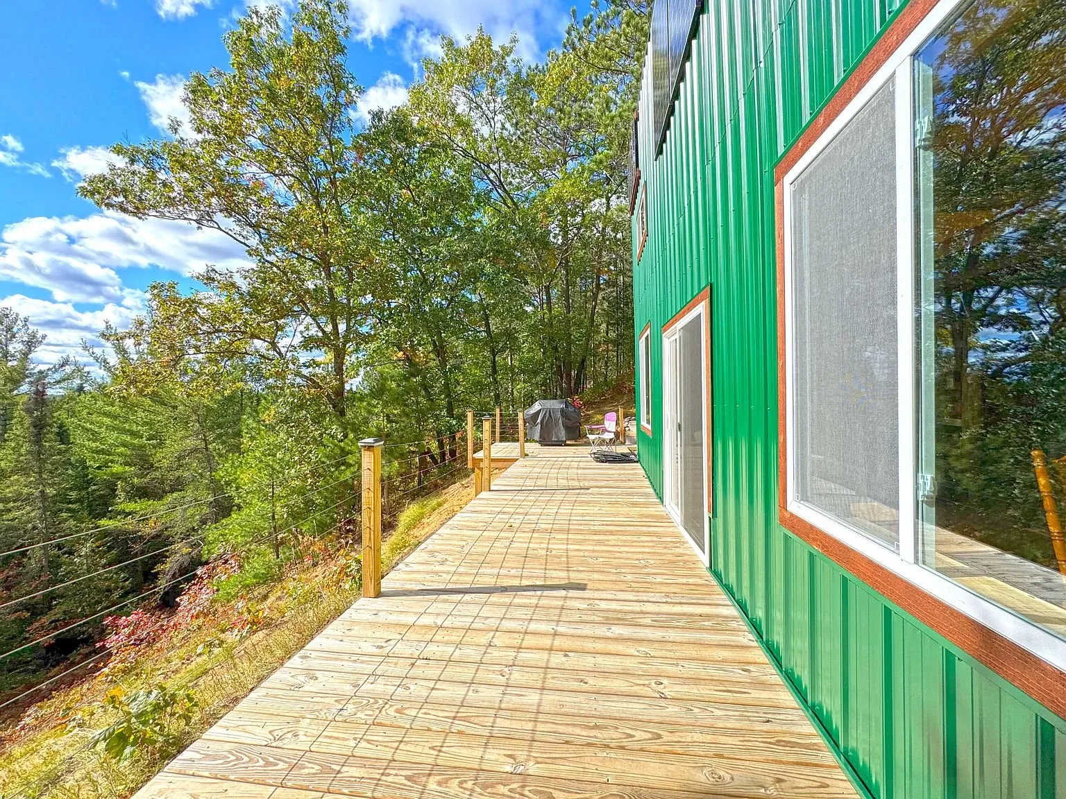 The boardwalk running the length of the cabin's green wall