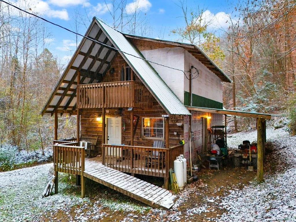 The front of the cabin: steep A-frame roof, deck, and a balcony off the upper floor