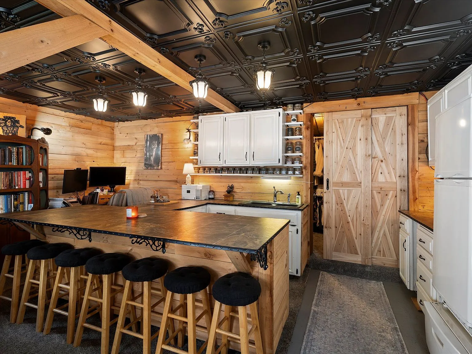 The living area with a wood stove, barn-style sliding door and exposed timber beams