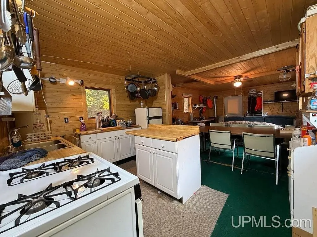 The kitchen with a propane range, cabinets and open shelving