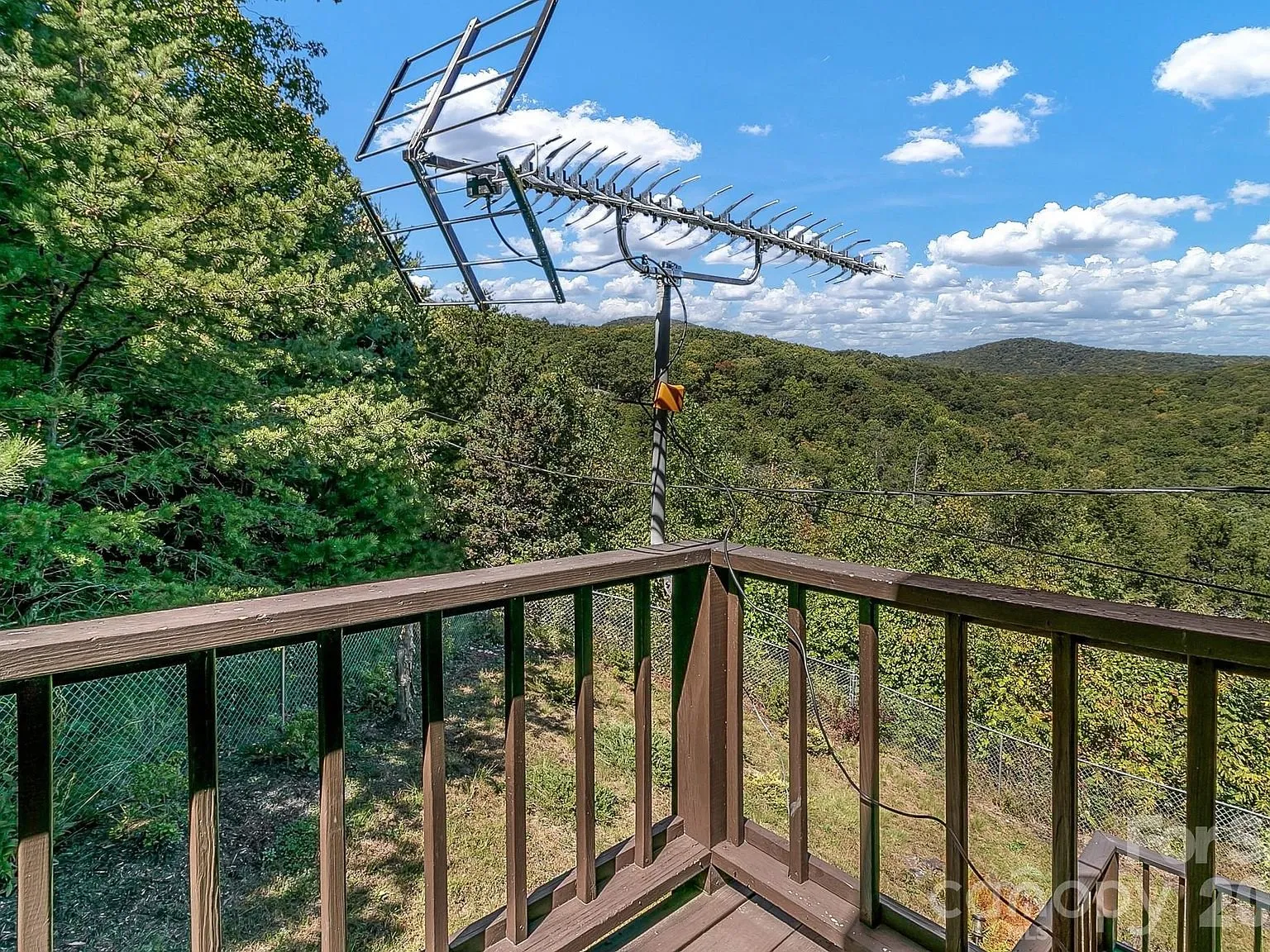 A deck corner with a TV antenna and a long-range mountain view