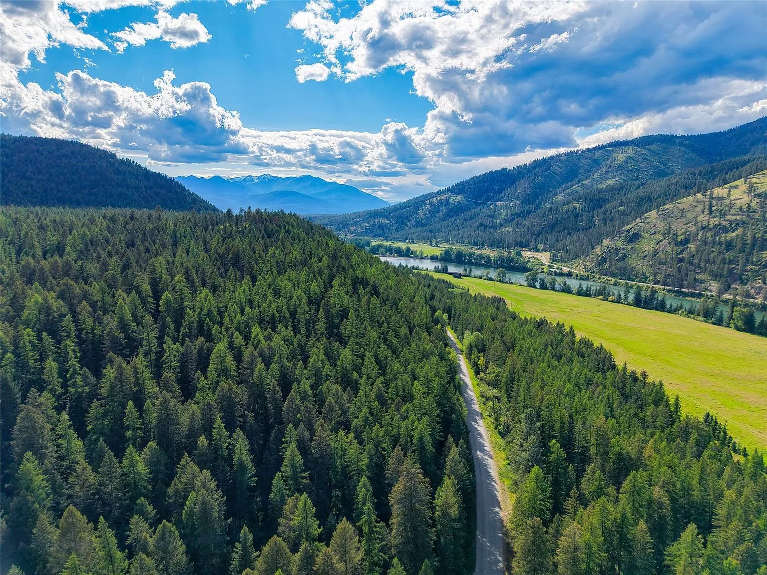 A wide aerial view of farmland and forest along the river valley