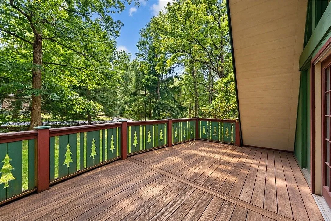 The deck railing with the wooded rear yard beyond