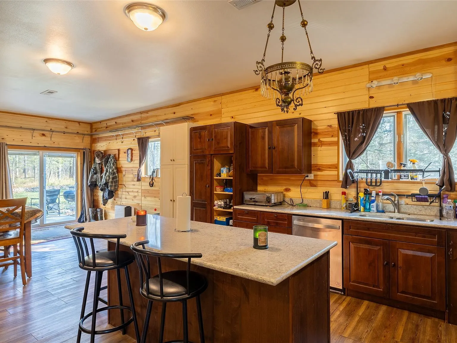 The kitchen seen from the dining side, with a farmhouse sink and windows