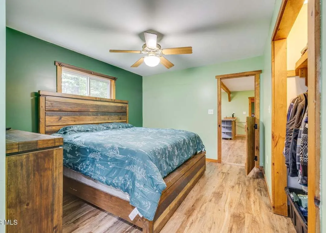 A second bedroom with a large window overlooking the property