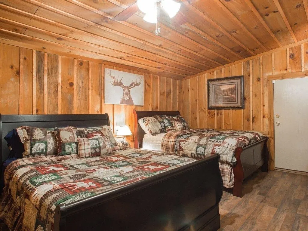 The lower bedroom with two beds and wood-paneled walls