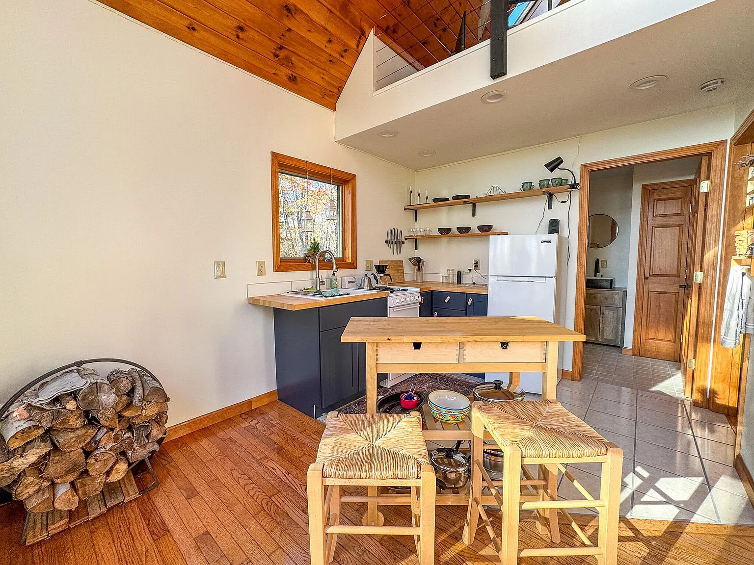 A second kitchen view with white cabinetry, a propane range and refrigerator