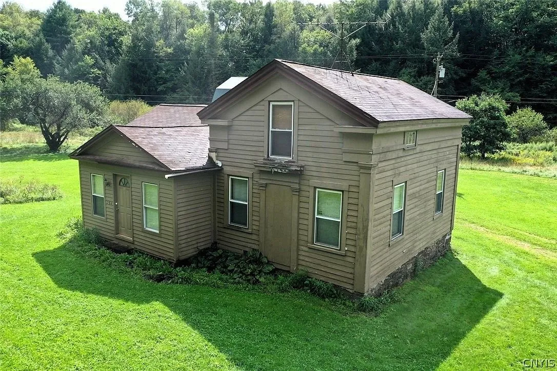 The farmhouse from the side with the two-story section