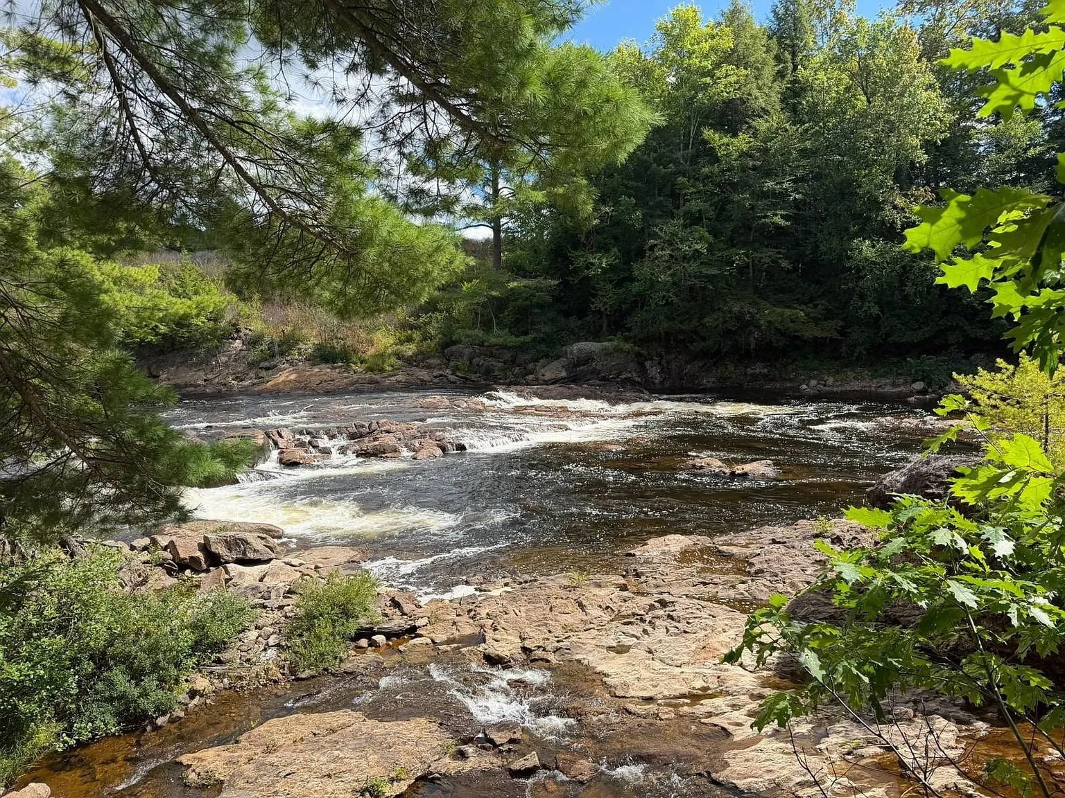 The river from the bank with the rapids and the far shore