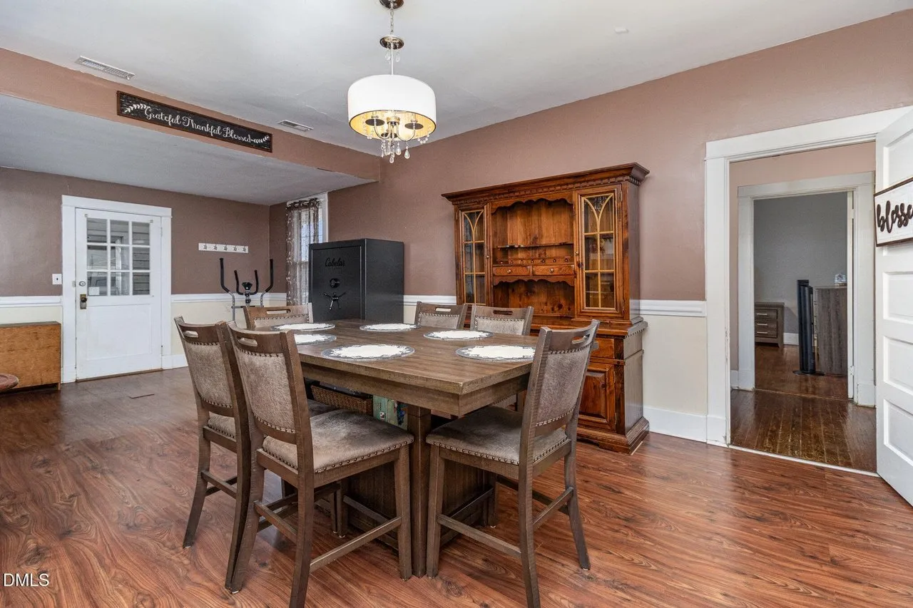 Dining area with a wood table and a china cabinet under a chandelier