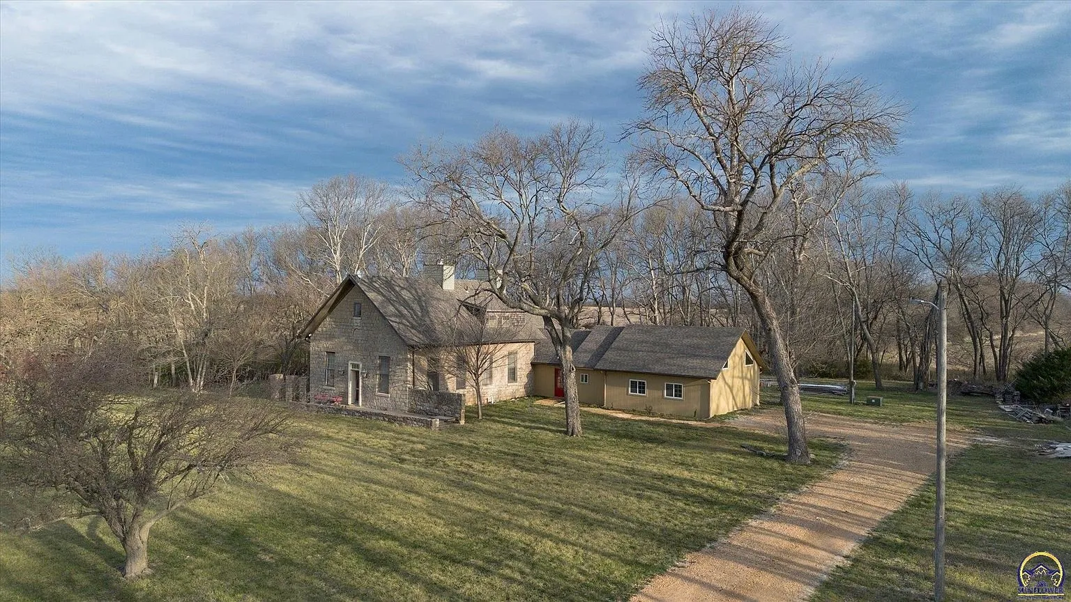 The house among the bare trees from the air in early spring