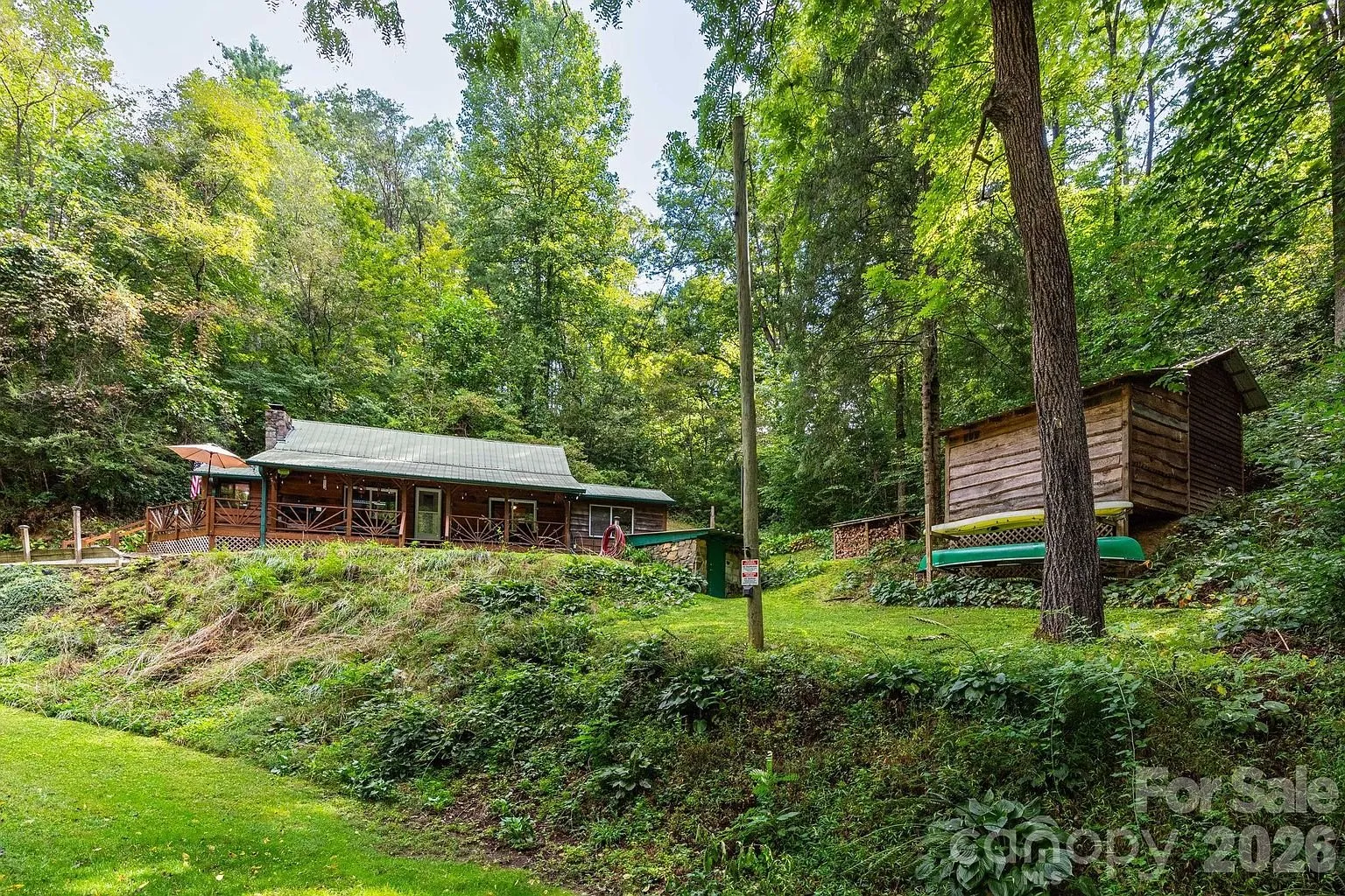 The cottage and the outbuilding across the lawn with the utility pole