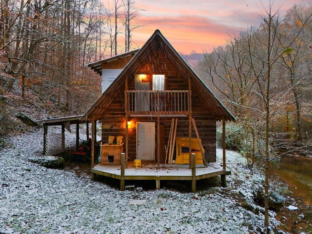 The front at dusk, lights on in the balcony door and the porch