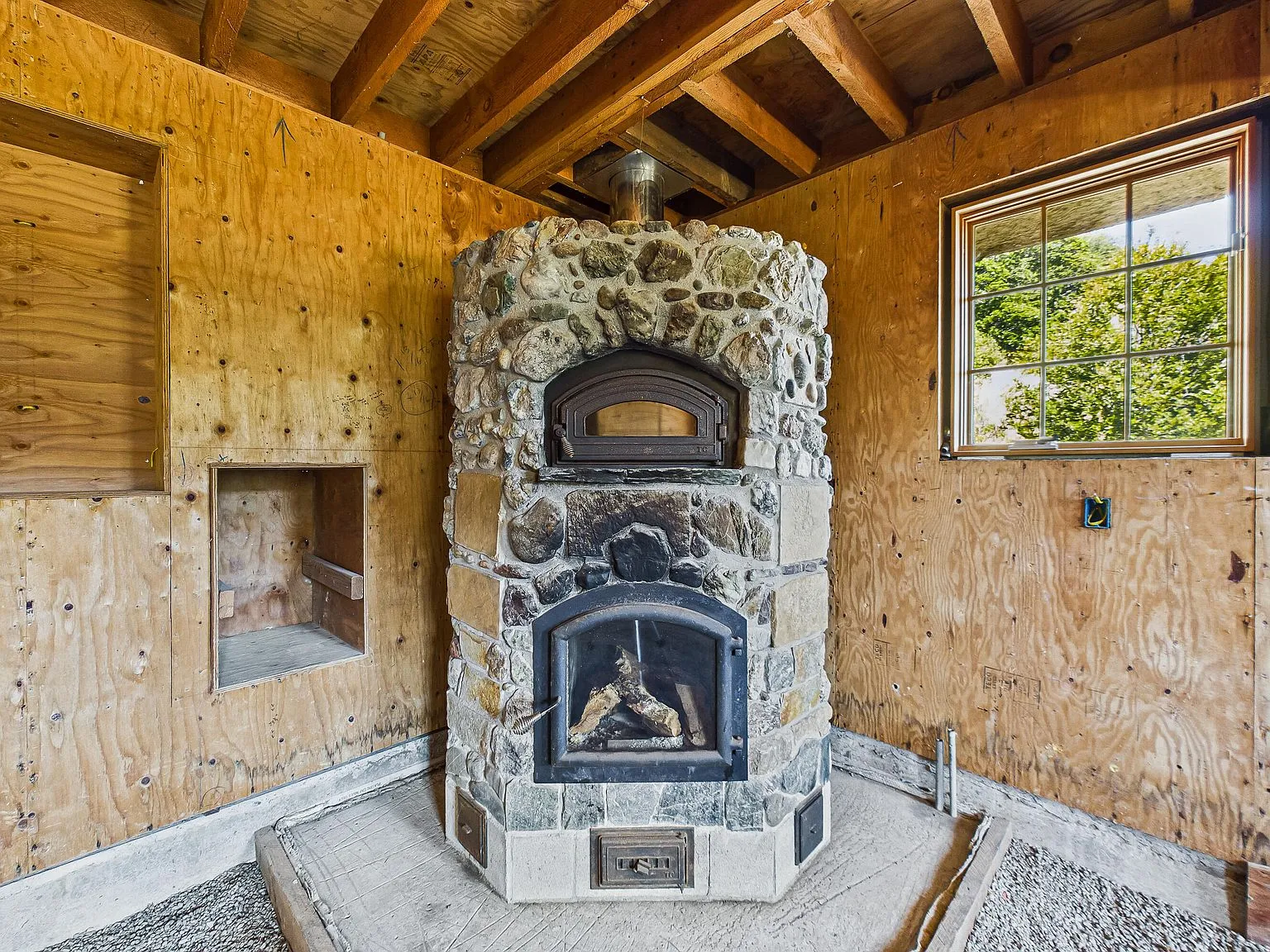 A close view of the stone TempCast masonry heater with its integrated pizza oven