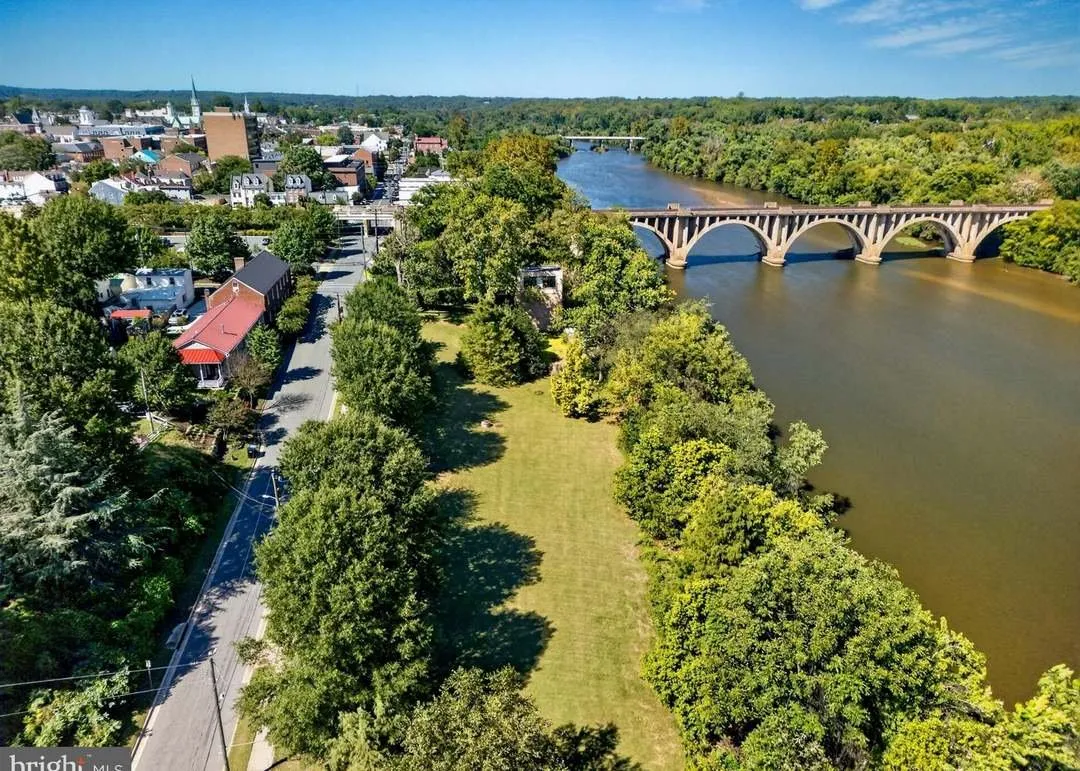 An aerial view of the open grounds and tree line along the riverbank