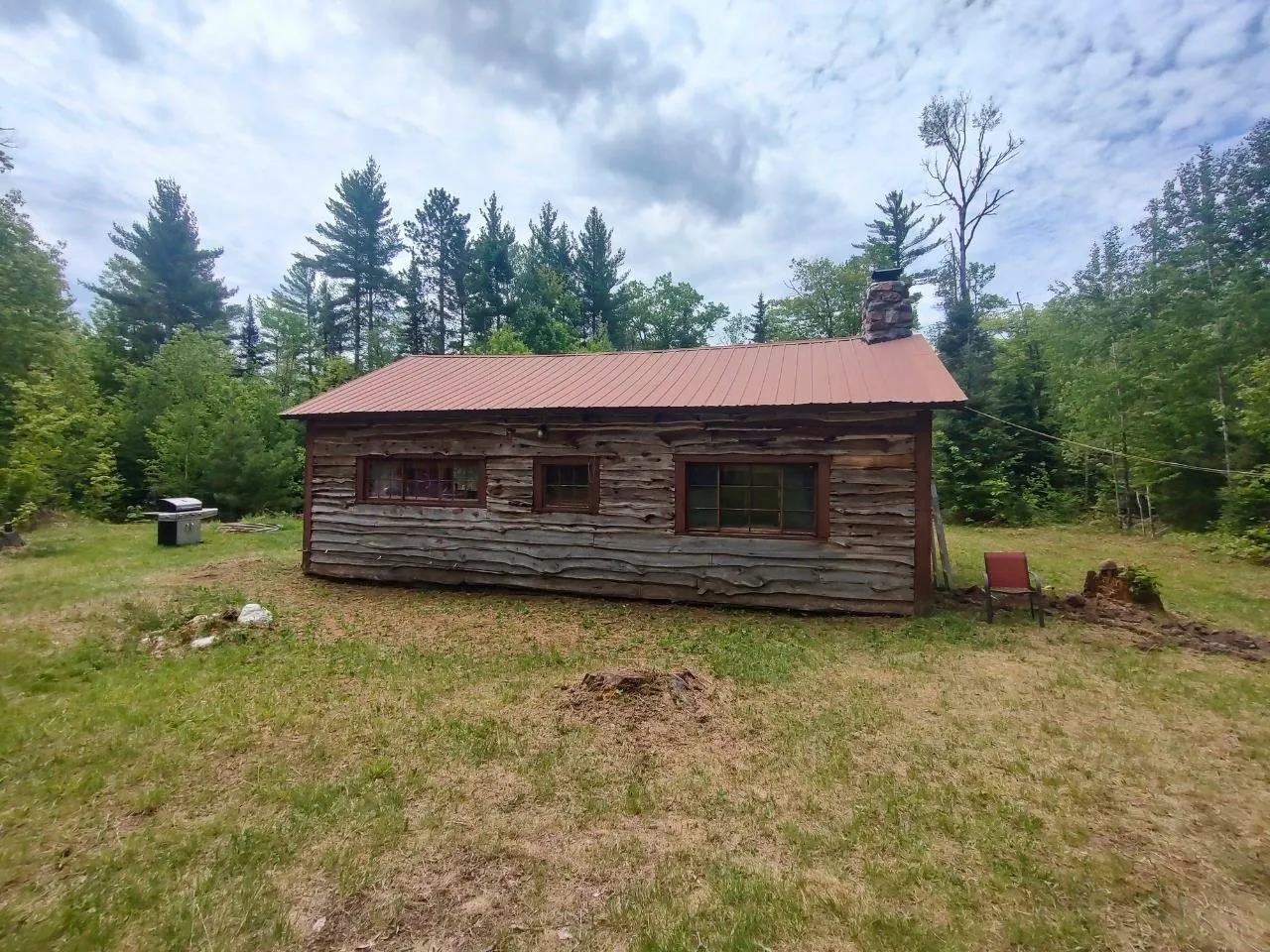 The back of the camp with a window cut into the log wall