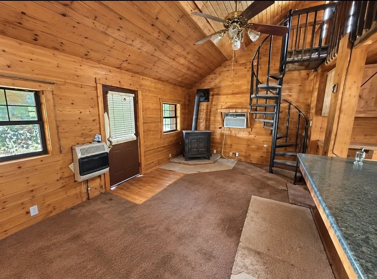 The kitchen with wood cabinets, a double sink and a window over the counter