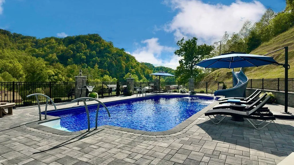The pool from the deck, lounge chairs and a canopy along one side