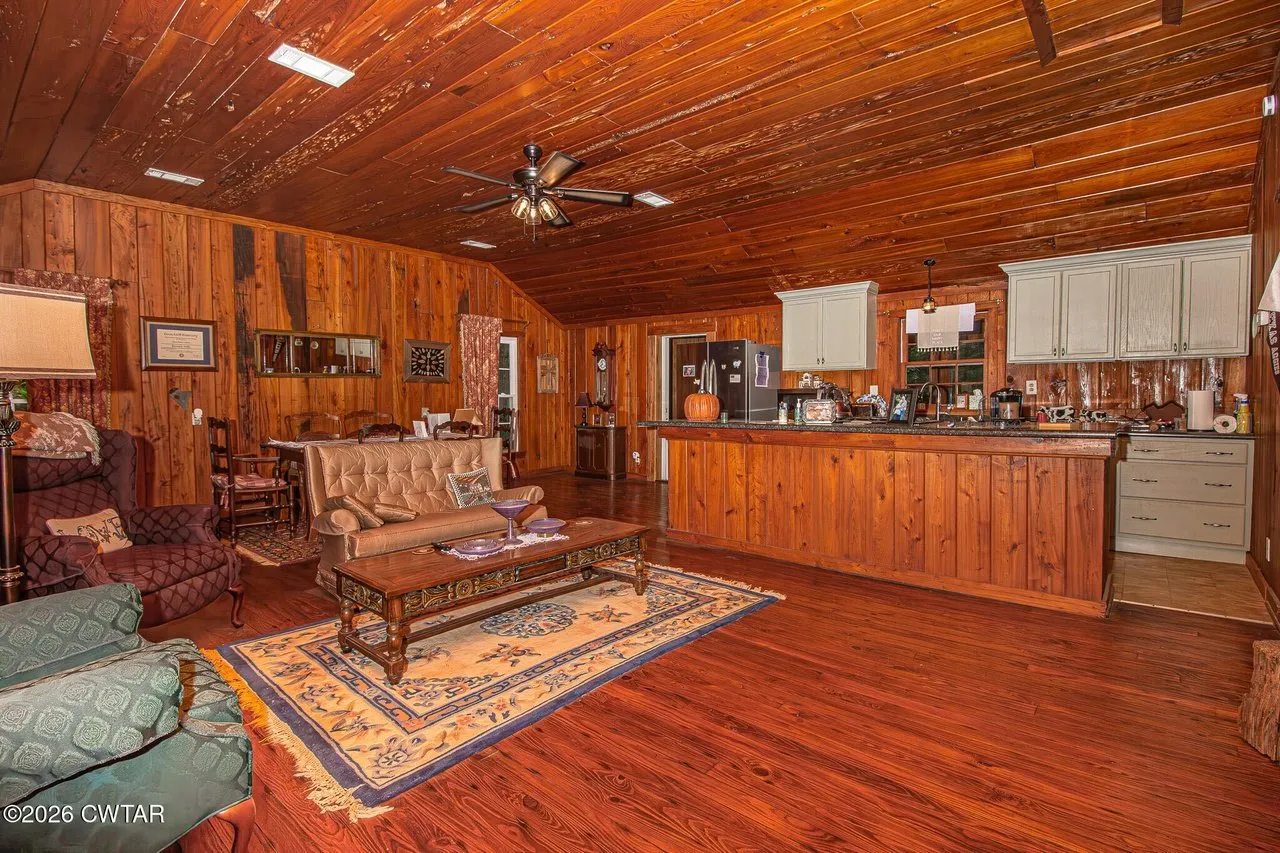 The great room with pecky cypress ceiling, pine floors and the kitchen along the far wall