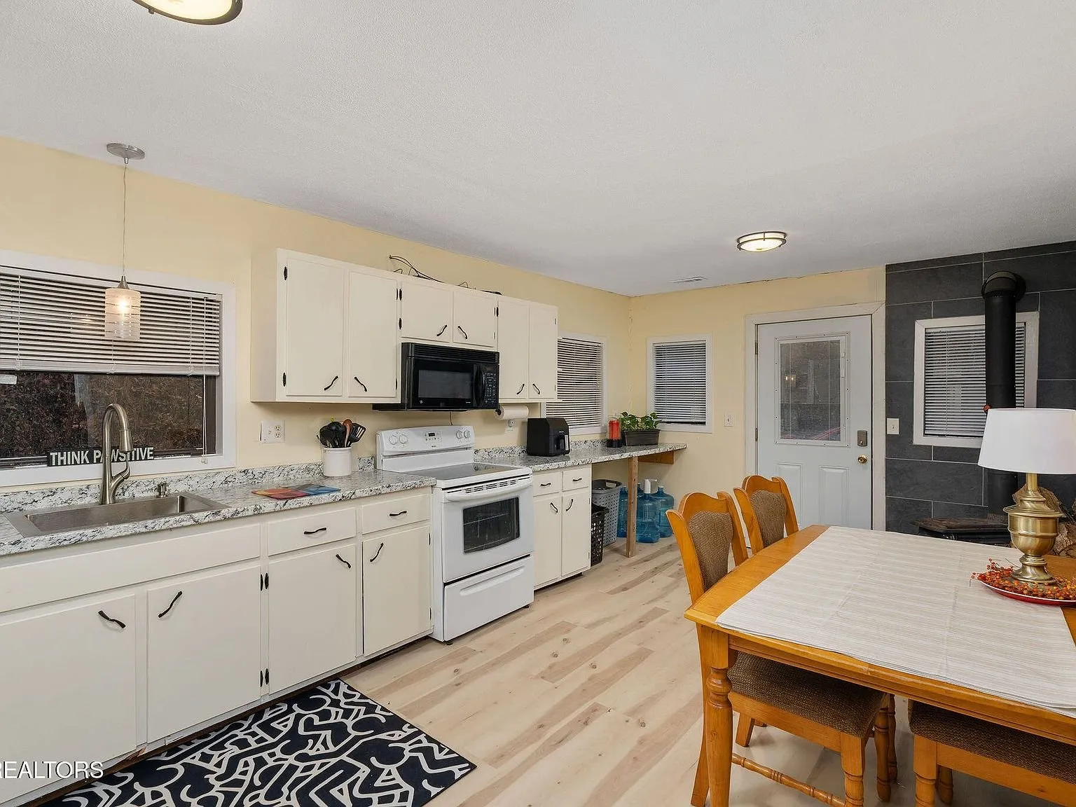 A second view of the kitchen and dining area with stainless appliances