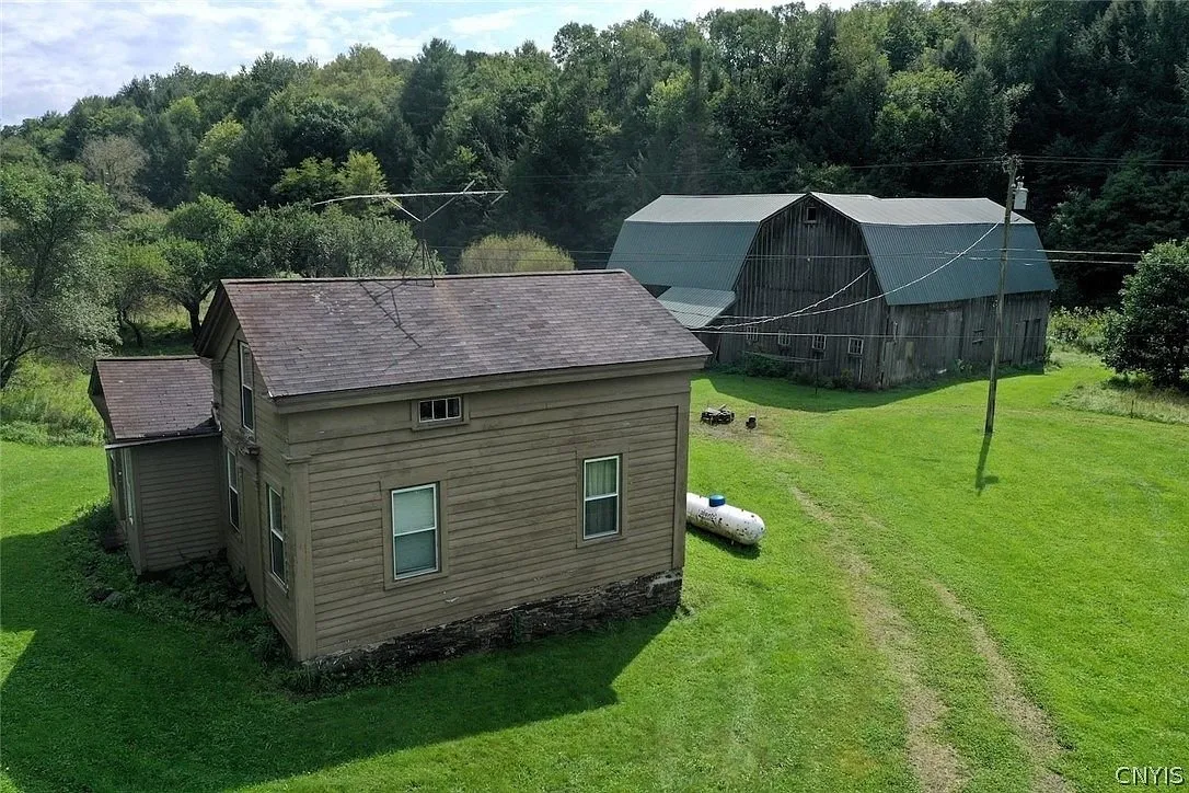 The back of the farmhouse with the barn and the propane tank beyond