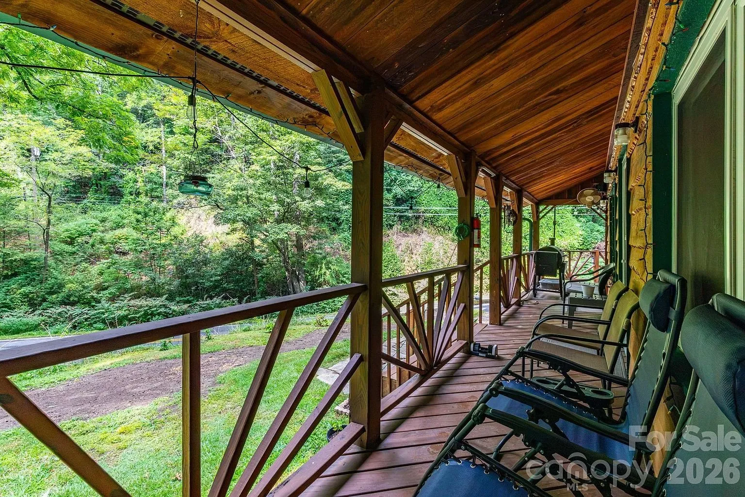 The covered porch with its chairs and the log rail