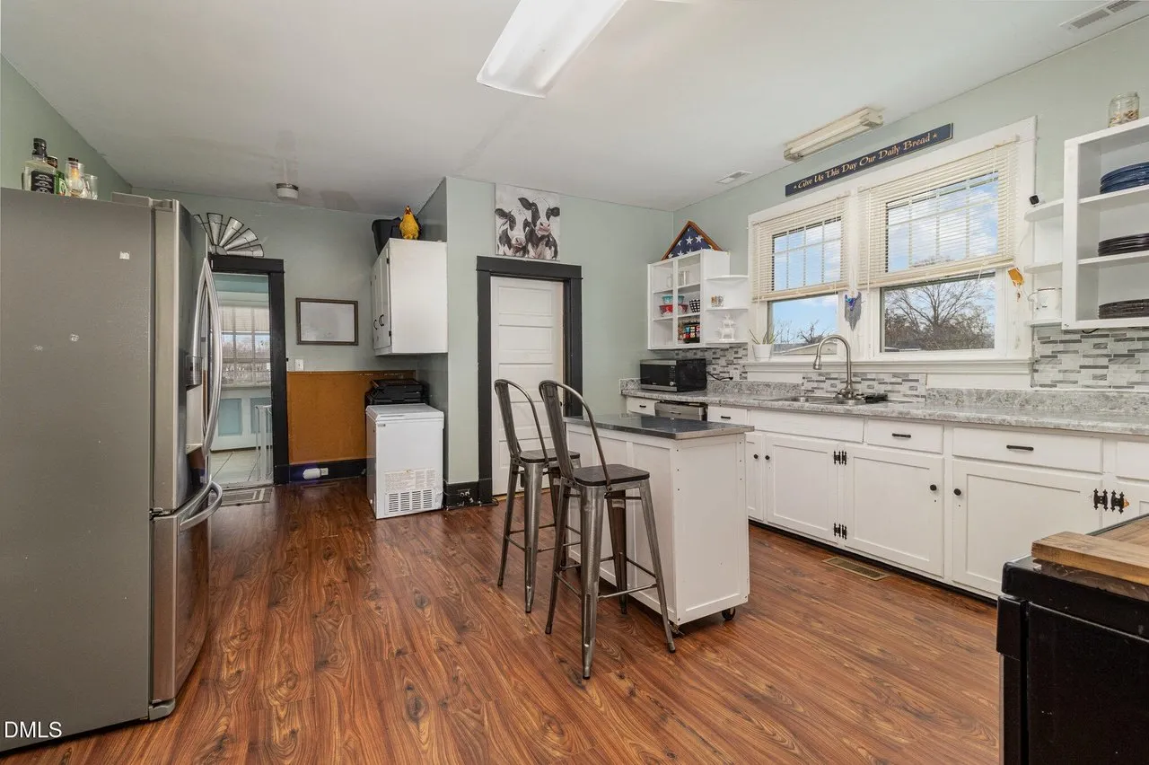 Kitchen with white cabinets, a stainless range and a breakfast bar