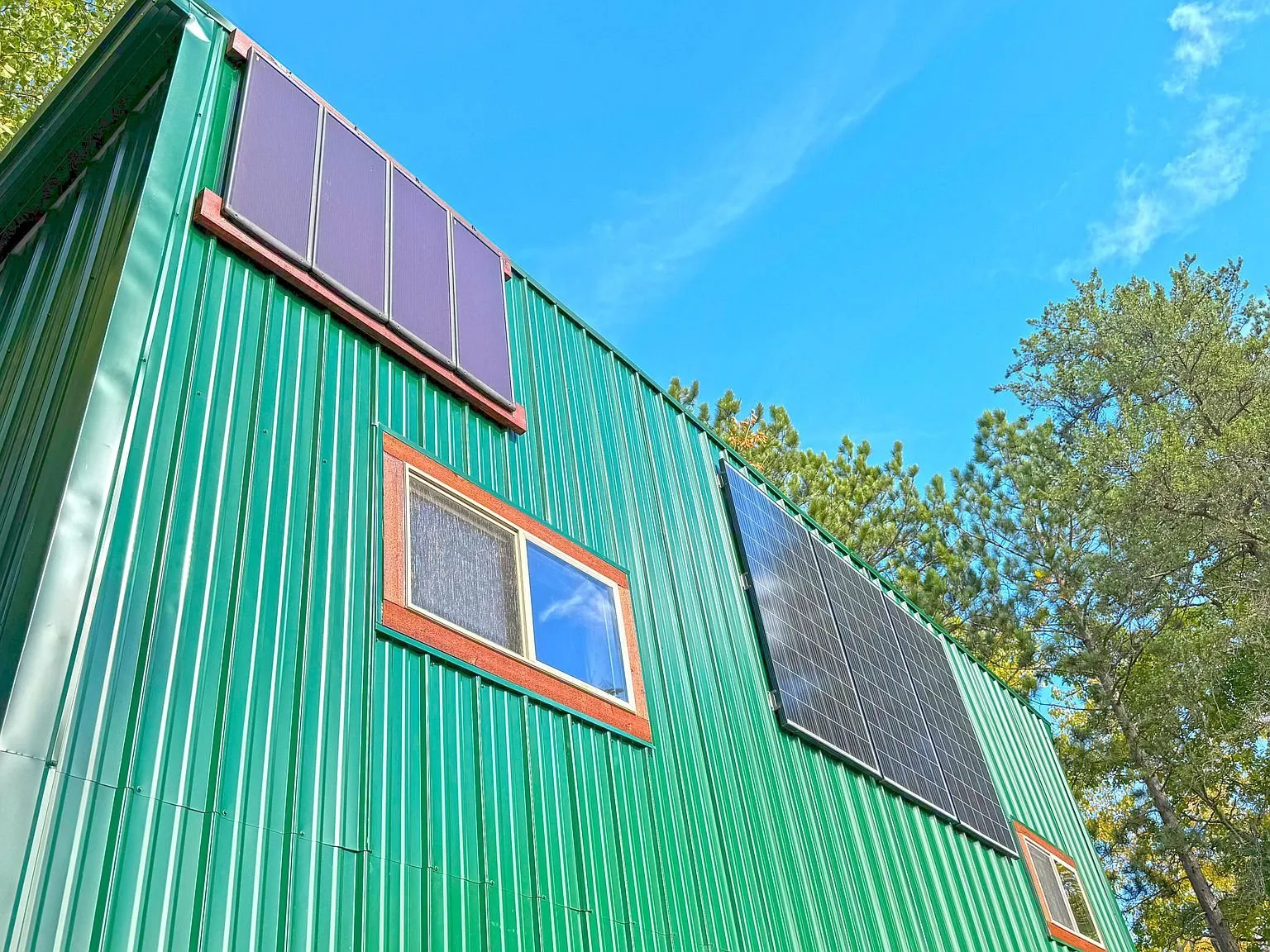 Solar panels mounted on the cabin's green metal roof