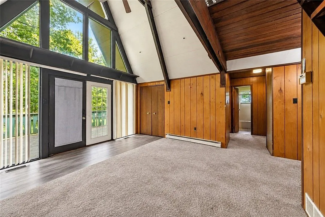 The vaulted great room with the brick fireplace and exposed beams